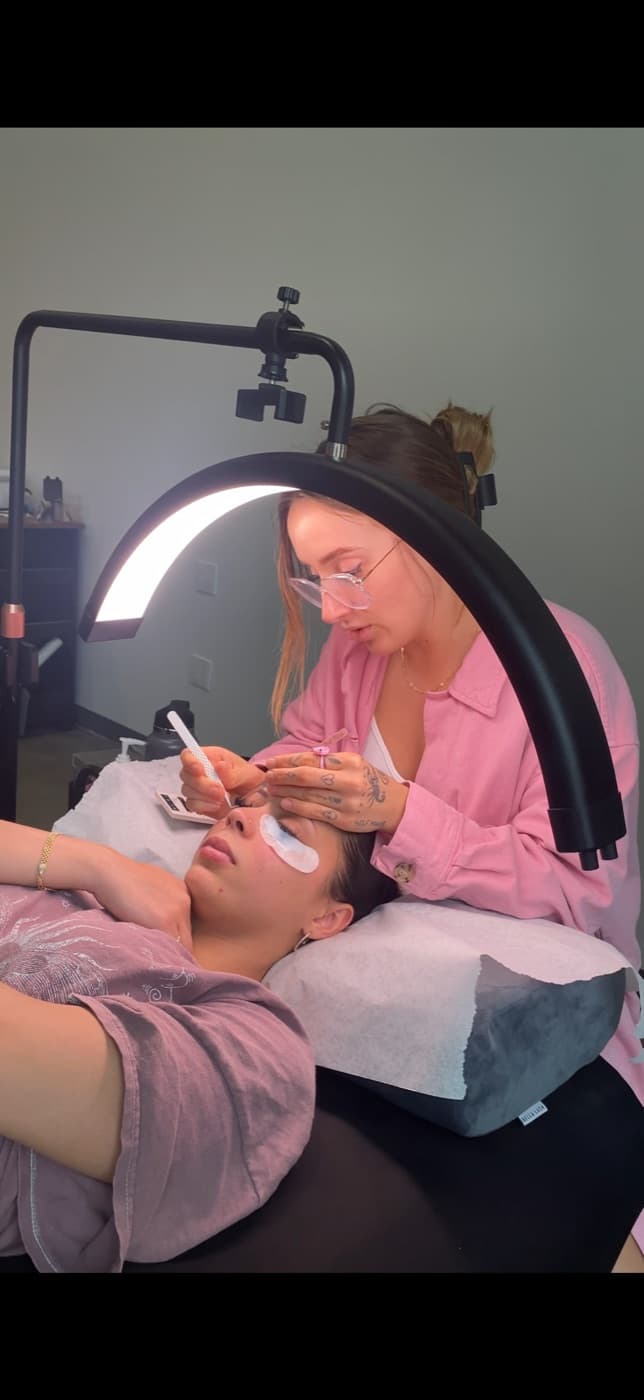 Miranda working on a client under a ring light in her studio